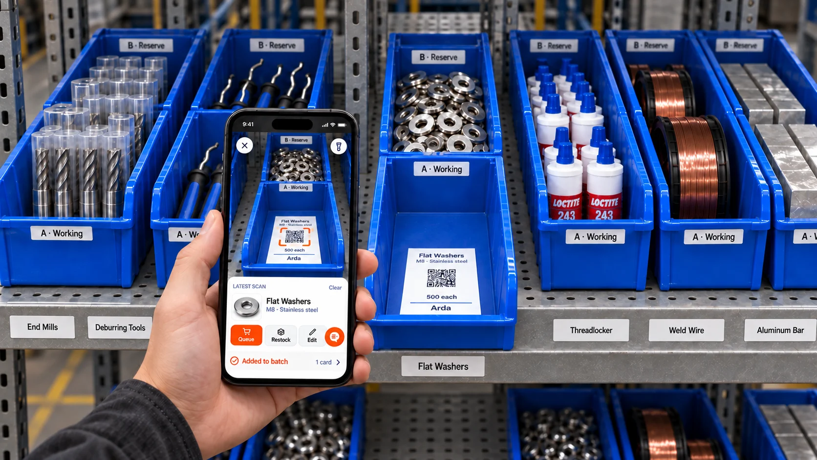 A worker scans an Arda washer card with a phone beside working and reserve stock on a shop shelf.